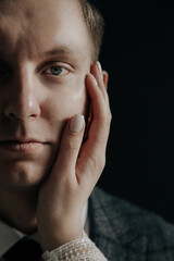 the girl gently puts her hand on the guy's face. The bride touches the groom's cheek with love.