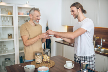 Smiling couple having breakfast together at home and feeling good