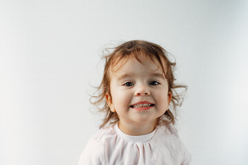 Naklejka premium baby girl on a white background looks at the camera and smiles