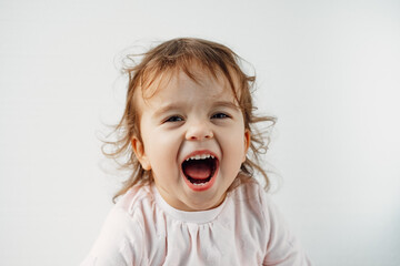 a child on a white background shows his tongue in his mouth, emotions.