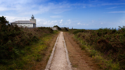 Fototapeta na wymiar Paisaje de un camino que conduce al faro de Cabo Busto y al fondo, la mar y el cielo.