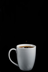 Kaffeetropfen spritzt in eine weiße Tasse