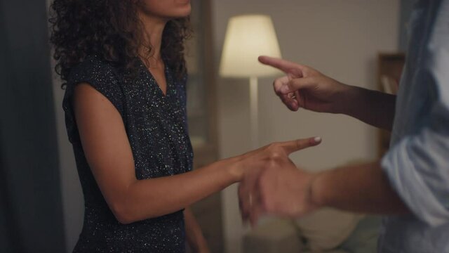 Midsection footage of unrecognizable stressed-out couple fighting at home in evening pushing each other gesturing emotionally