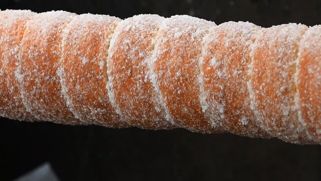 Close up chimney cake baking and rolling