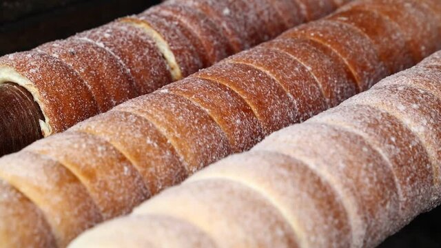 Close up chimney cake baking and rolling