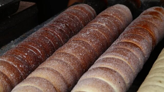Close up chimney cake baking and rolling
