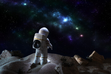 Astronaut in a space suit looking at milky way galaxy.