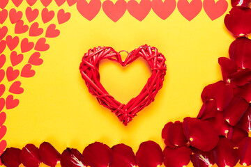 Banner orange background for the inscription lies a heart made of straw, petals of red roses and paper hearts of different sizes. Place for your text.