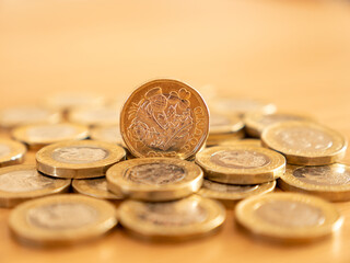 Close up of many GBP one pound coins on the table surface, UK