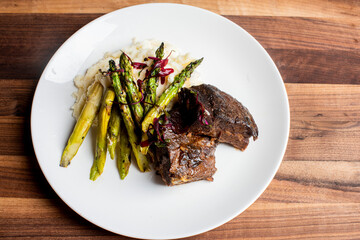 Meatloaf dinner. Homemade meatloaf steak, served with garlic mashed potatoes and farm fresh asparagus. Traditional classical American or French Bistro entree, meatloaf and mashed potatoes. 