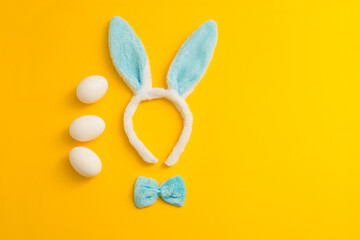 easter concept with eggs and bunny ears, yellow background