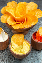Vertical view of homemade crispy potato chips ketchup mayonnaise and sauce on gray background stock image