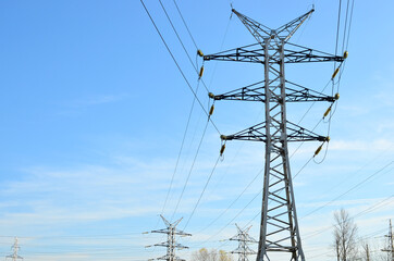 High voltage power lines on blue sky background. Electric transmission pylon tower. Wire electrical energy. Electricity concept