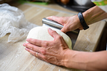 women's hands prepare dough in the home kitchen