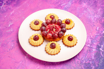 front view yummy grape cookies inside plate on pink background sweet dessert biscuit pie