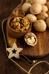 many whole walnuts on a board next to chopped walnuts and walnut kernels on a wooden background