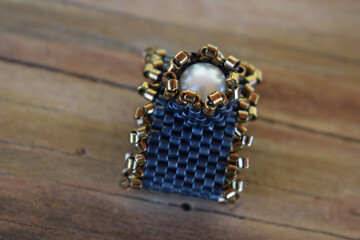 large ring with pearl on a wooden surface