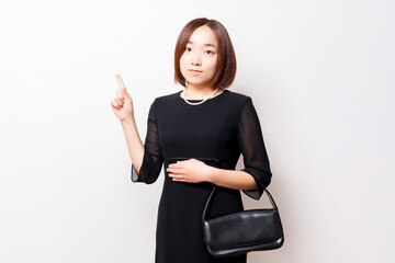喪服を着たポイントを示す女性