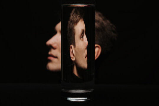 Fototapeta portrait of a man in profile through a container of water