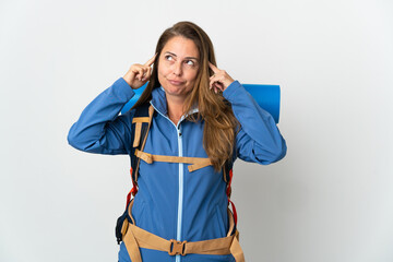 Middle age mountaineer woman with a big backpack over isolated background having doubts and thinking