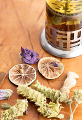 Different winter herbal tea set on wooden background dried rosehip and roses, slices of lemon, marigold petals, sage, ginger, rosehip, cinnamon, Mallow blossom, free space for text in the upper left o