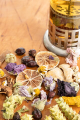 Different winter herbal tea set on wooden background dried rosehip and roses, slices of lemon, marigold petals, sage, ginger, rosehip, cinnamon, Mallow blossom, free space for text in the upper left o