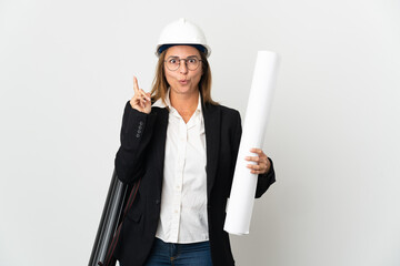 Middle age architect woman with helmet and holding blueprints over isolated background intending to realizes the solution while lifting a finger up
