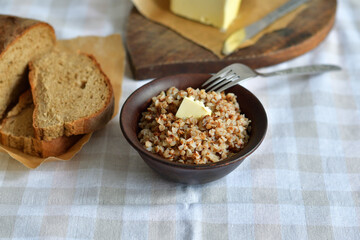 Buckwheat porridge with butter.Bowl of tasty buckwheat porridge on wooden table.Healthy breakfast for schoolchildren.