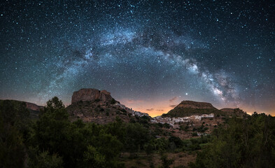 Night panoramic view of the Milky Way over a town in Spain, Chulilla. Night landscape of a village between mountains illuminated by the stars of the Milky Way. Chulilla, a town in Valencia, Spain