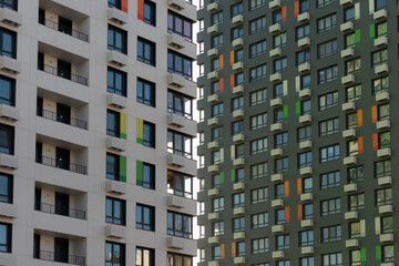 Fototapeta na wymiar Solid facades of the houses. A city of only houses. Bright sun and high-rises.
