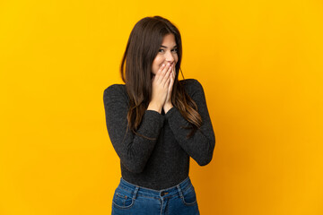 Teenager Brazilian girl isolated on yellow background happy and smiling covering mouth with hands