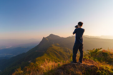 Fototapeta premium Photographer over Doi Pha Tang viewpoint photographing beautiful landscape view located in Chiang Rai province, Thailand