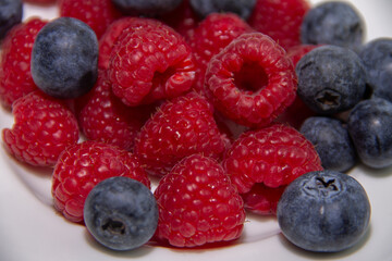 ripe red raspberries and dark blue blueberries
