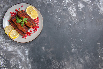 Fototapeta na wymiar top view meat cutlets long formed with lemon slices on the grey background meal photo dish