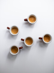 Five cups of espresso on white background