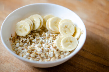 Bowl of oatmeal porridge with banana and cottage cheese hot and healthy breakfast every day, diet food.