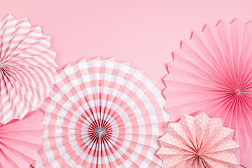 Festive party background with pink paper circle fans over pastel background. Festival, birthday, baby shower decoration