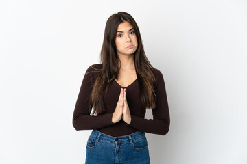 Teenager Brazilian girl isolated on white background keeps palm together. Person asks for something