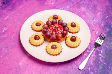 front view yummy little cookies with grapes on pink background biscuit sweet dessert cake