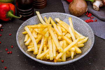 french fries on grey plate on black table