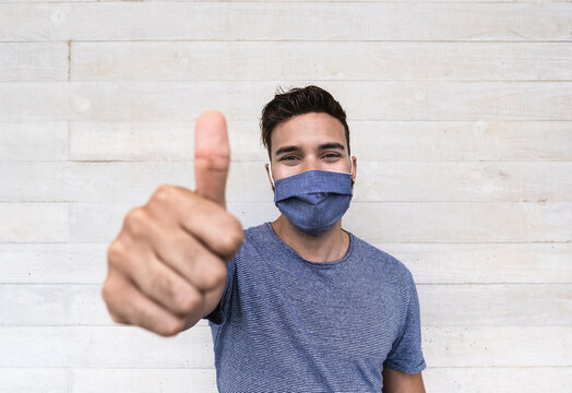 Young Latin Man Smiling While Wearing Protective Face Mask And Doing Thumb Up Gesture - Concept Of Positivity And Coronavirus