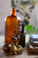 Hand crafted gift, glass bottles, deer figurines, green plants on rustic wooden background