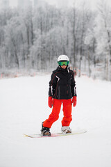 Naklejka premium Senior woman ride on snowboard stand in winter mountain