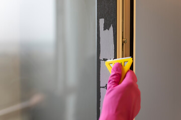 Removing protective tape from the window frame with scraper