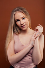 Naklejka premium young pretty girl with blond hair posing cheerful on brown background, lifestyle people concept