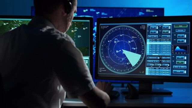 Workplace of the professional air traffic controller in the control tower. Caucasian aircraft control officer works using radar, computer navigation and digital maps.