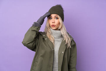 Teenager blonde girl with winter hat over isolated purple background has just realized something and has intending the solution