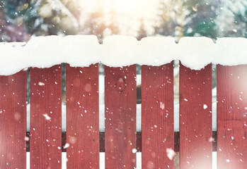 Wooden red fence in the snow. Winter background