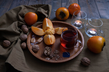 tea drink, walnuts, persimmon and caramel, near a candle and decorations