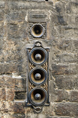 Close-up of an antique, rusty iron door bell on the exterior wall of an old brick building, Siena, Tuscany, Italy